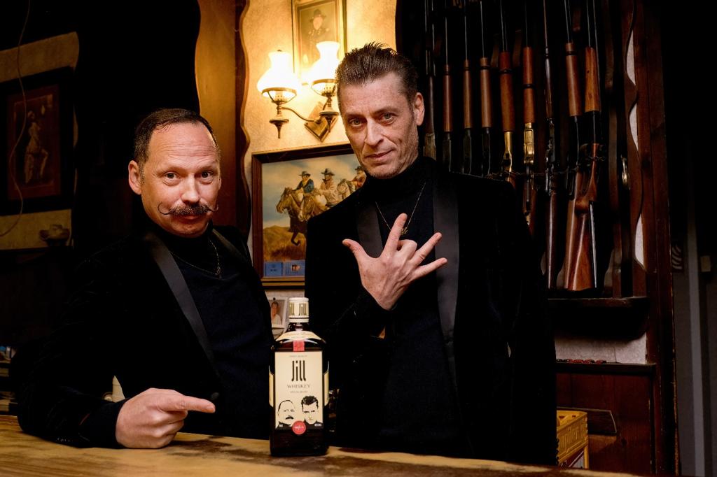 Bottle of whisky, two guys on top of a bar in a saloon